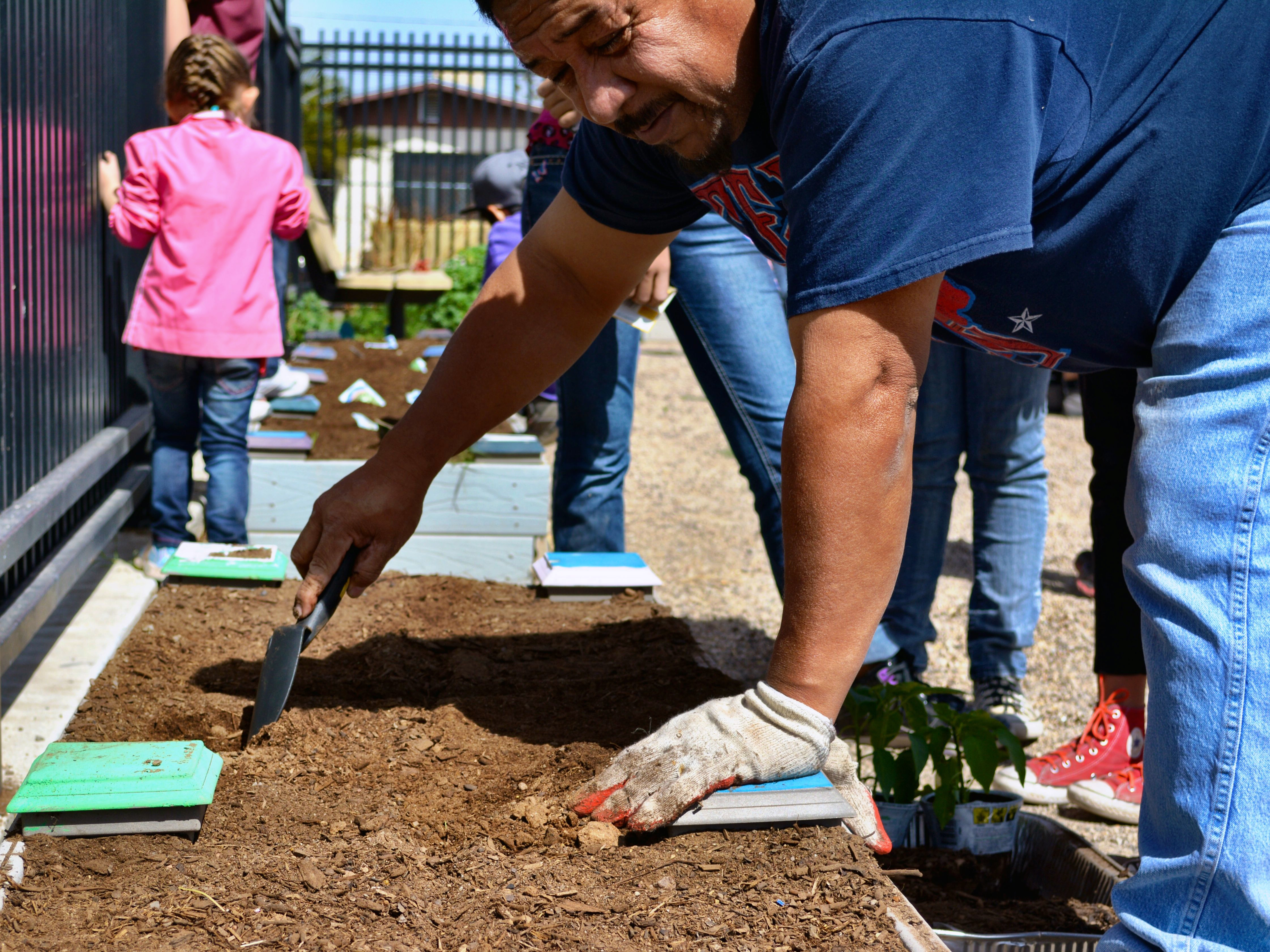 Volunteers dig in the soil to place plants. Photo Credit: City of El Paso Office of Resilience & Sustainability